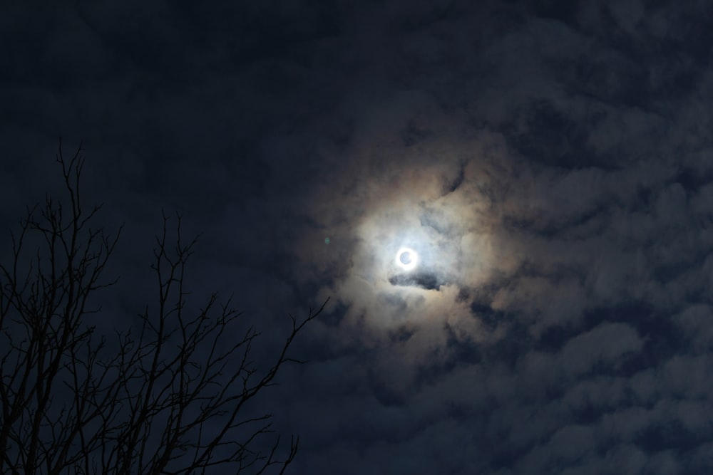 a full moon seen through the clouds in the night sky