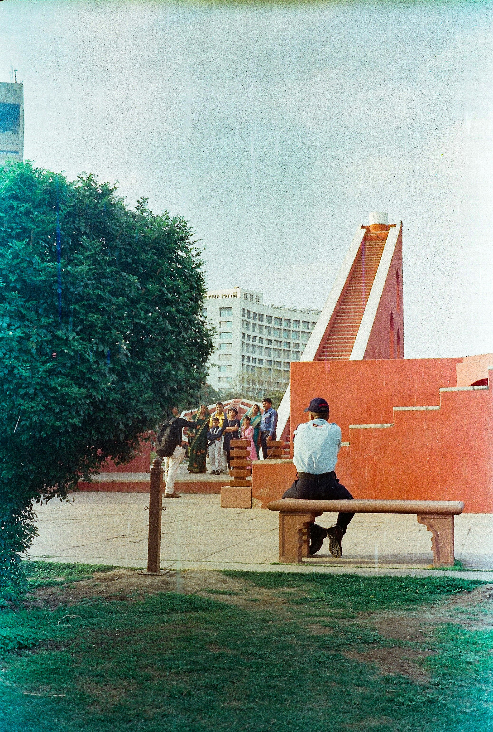 a man sitting on a bench in front of a building