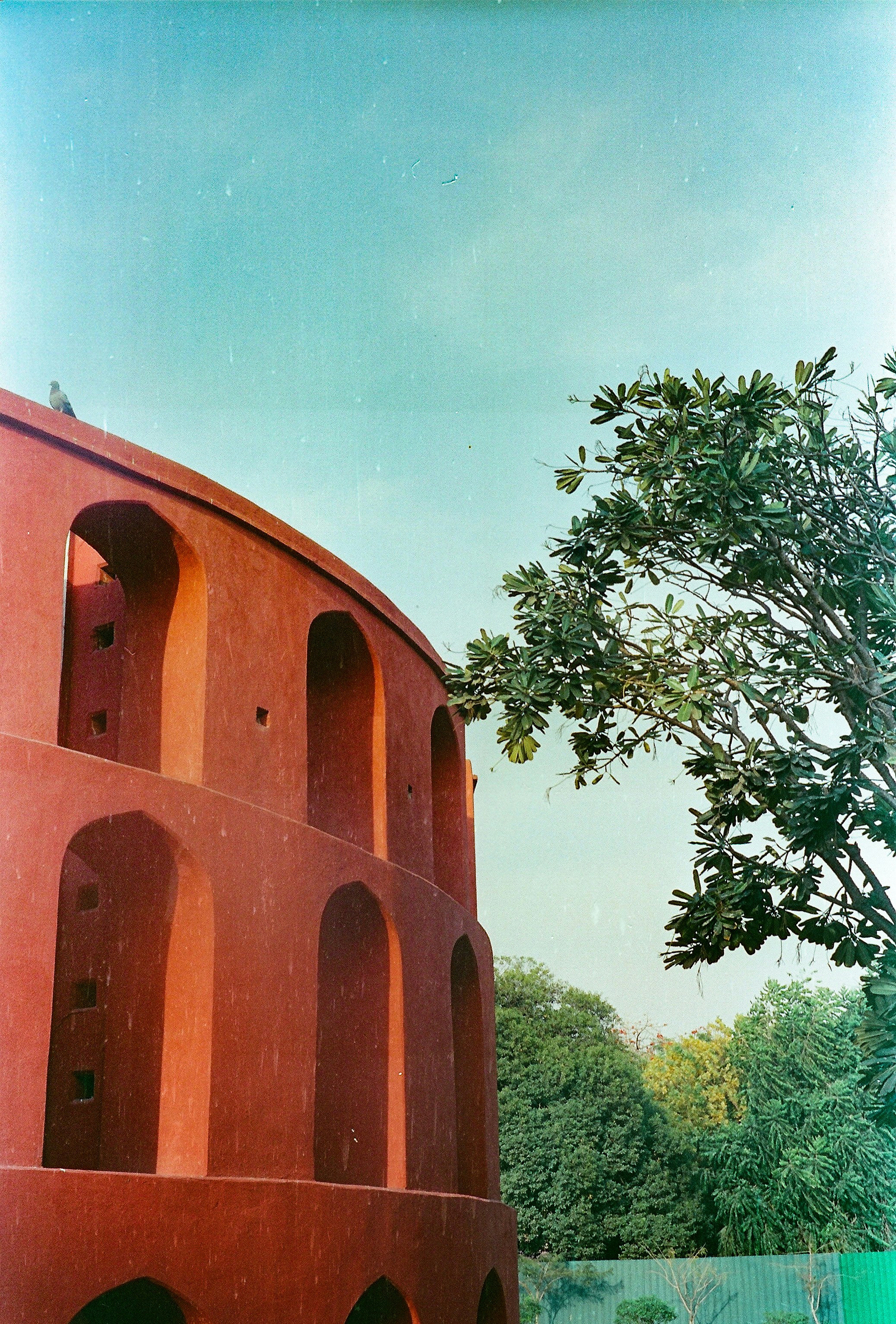 un edificio rosso con un albero sullo sfondo