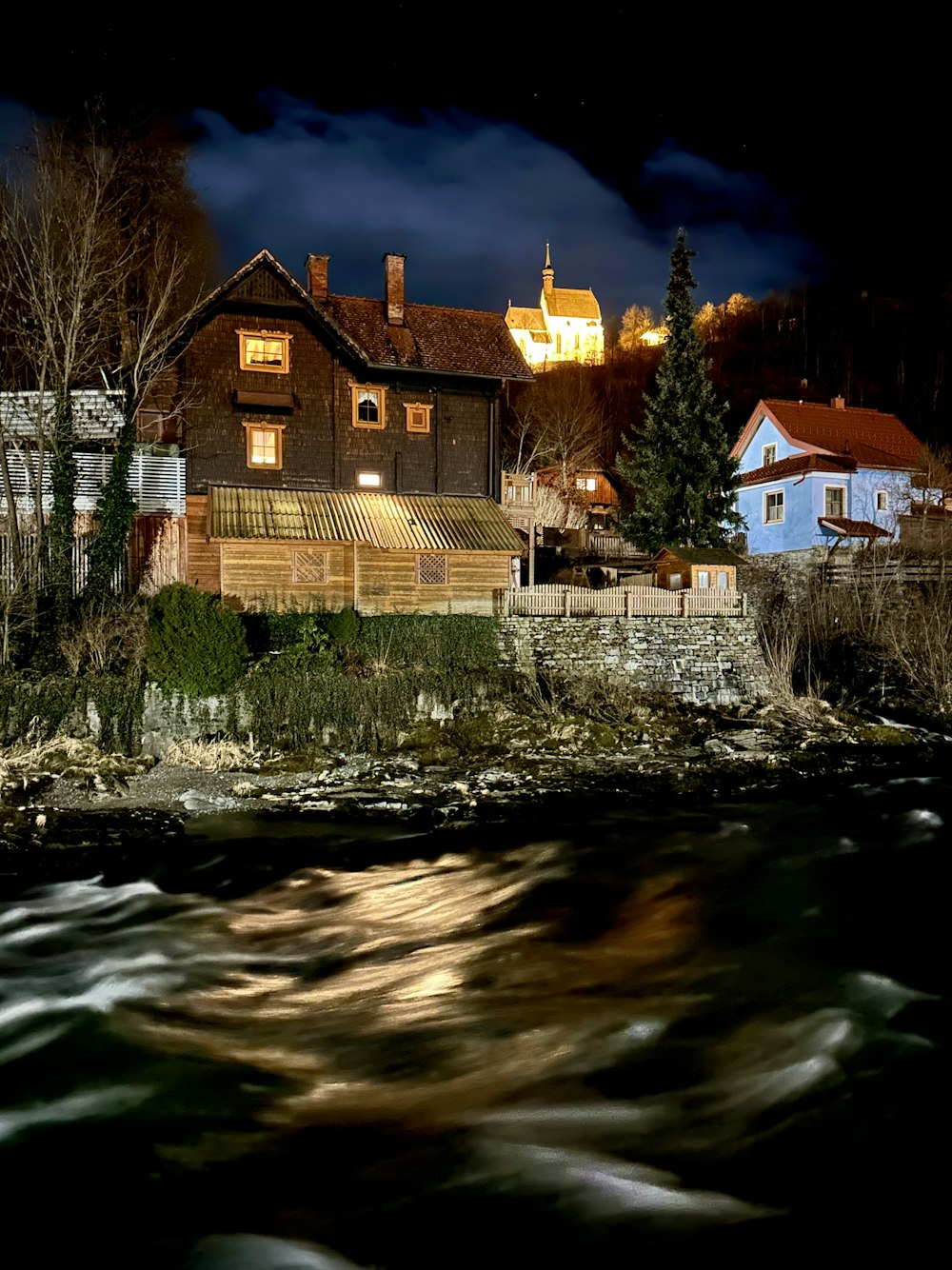 a house on the shore of a river at night