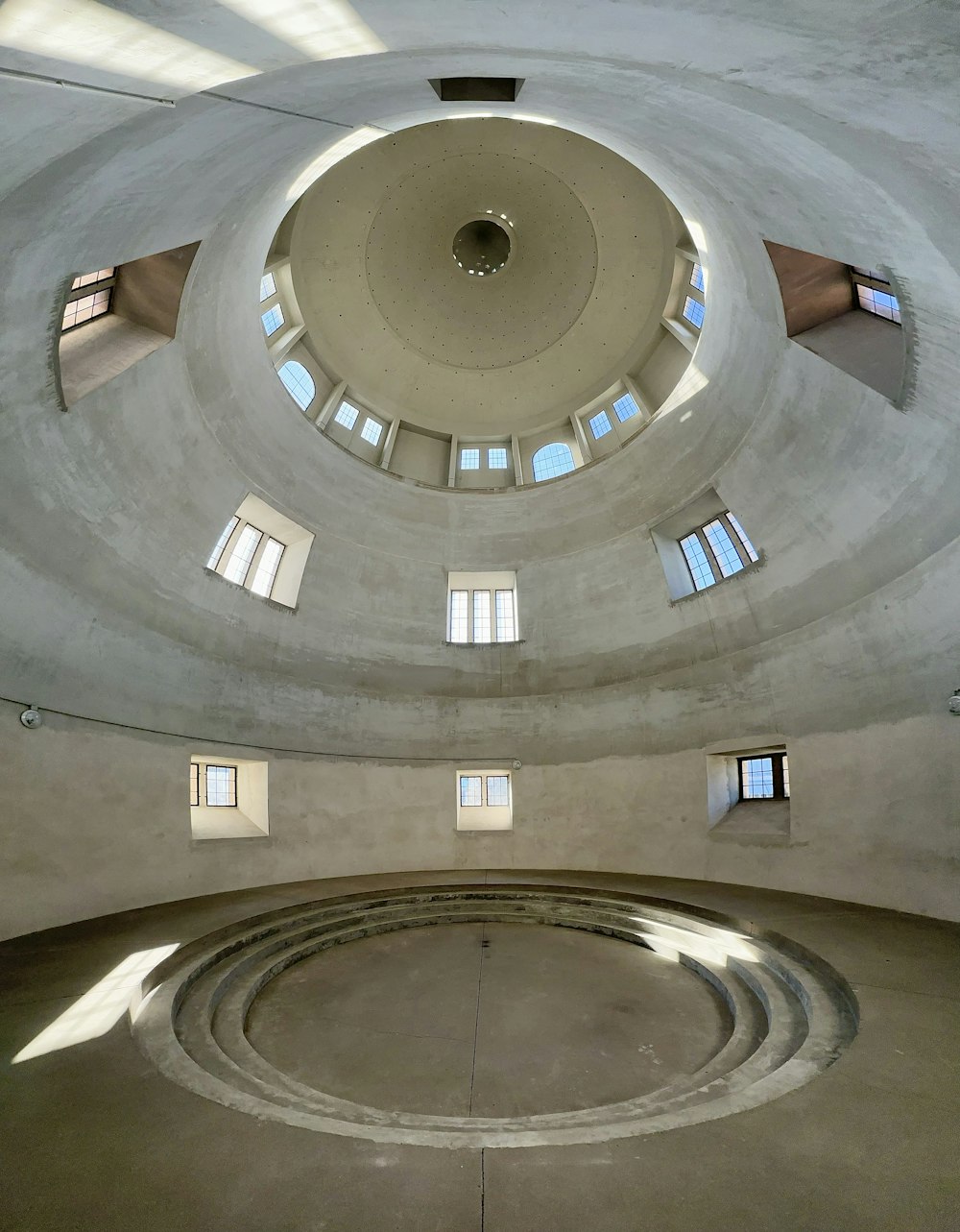 a circular room with windows and a spiral staircase