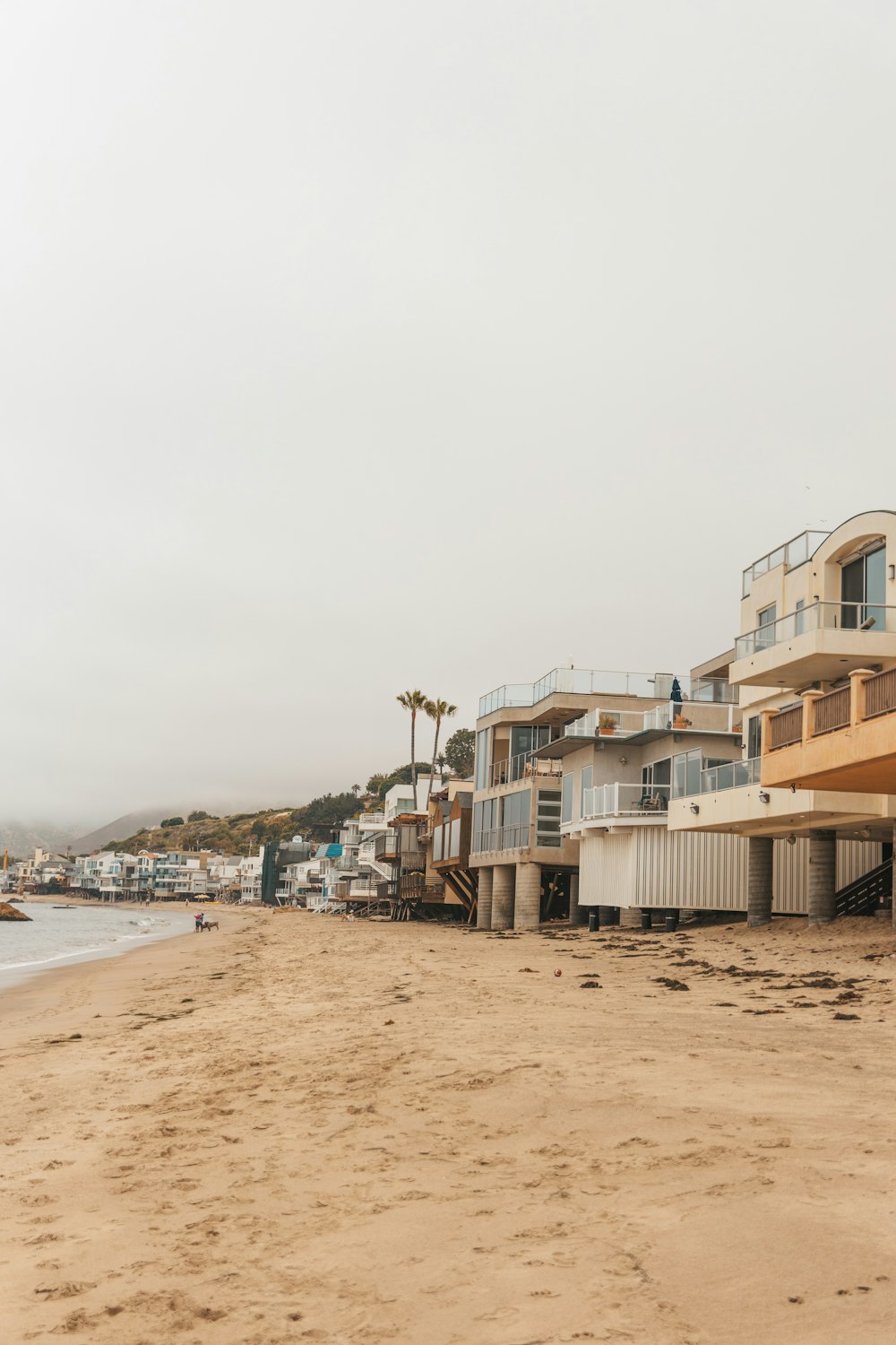 a sandy beach next to a row of houses