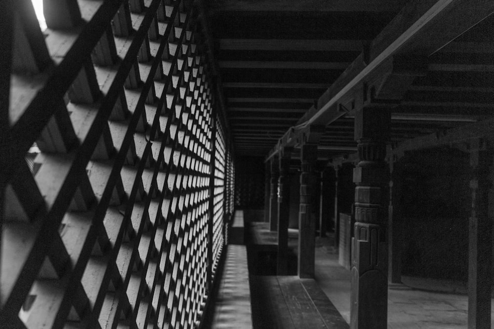 a black and white photo of a wall and a bench