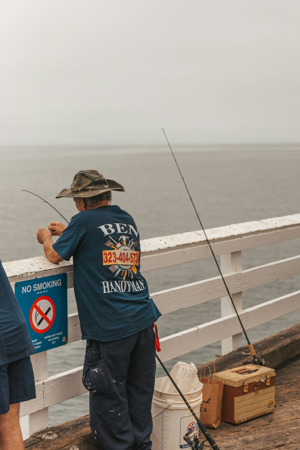 a couple of men standing next to each other on a pier