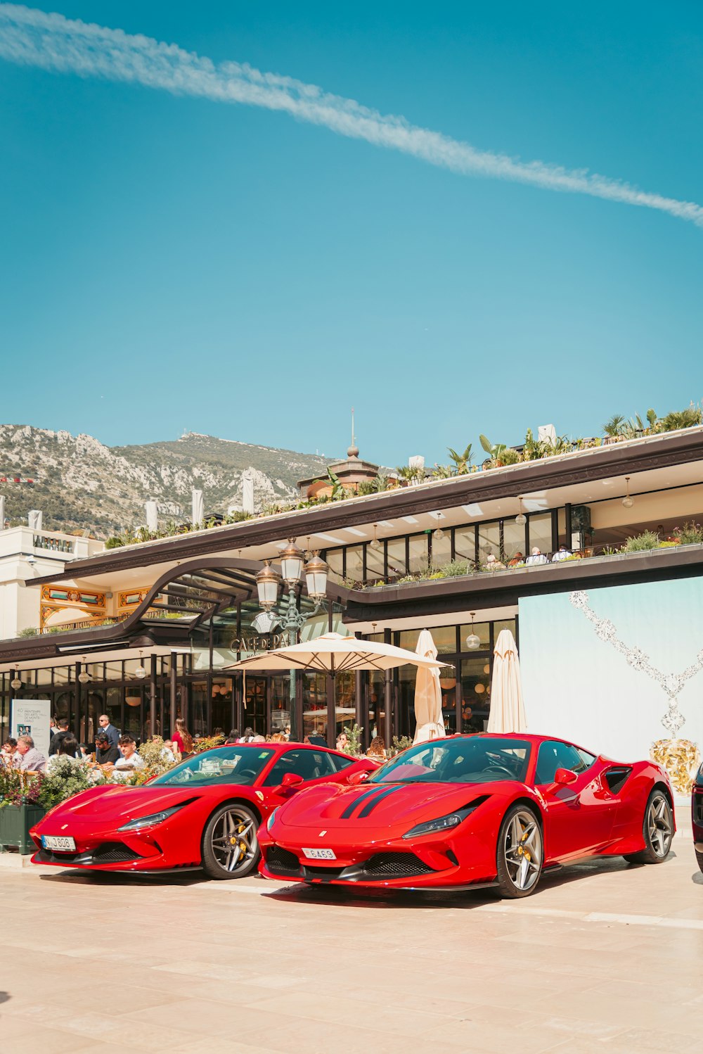 two red sports cars parked in front of a building