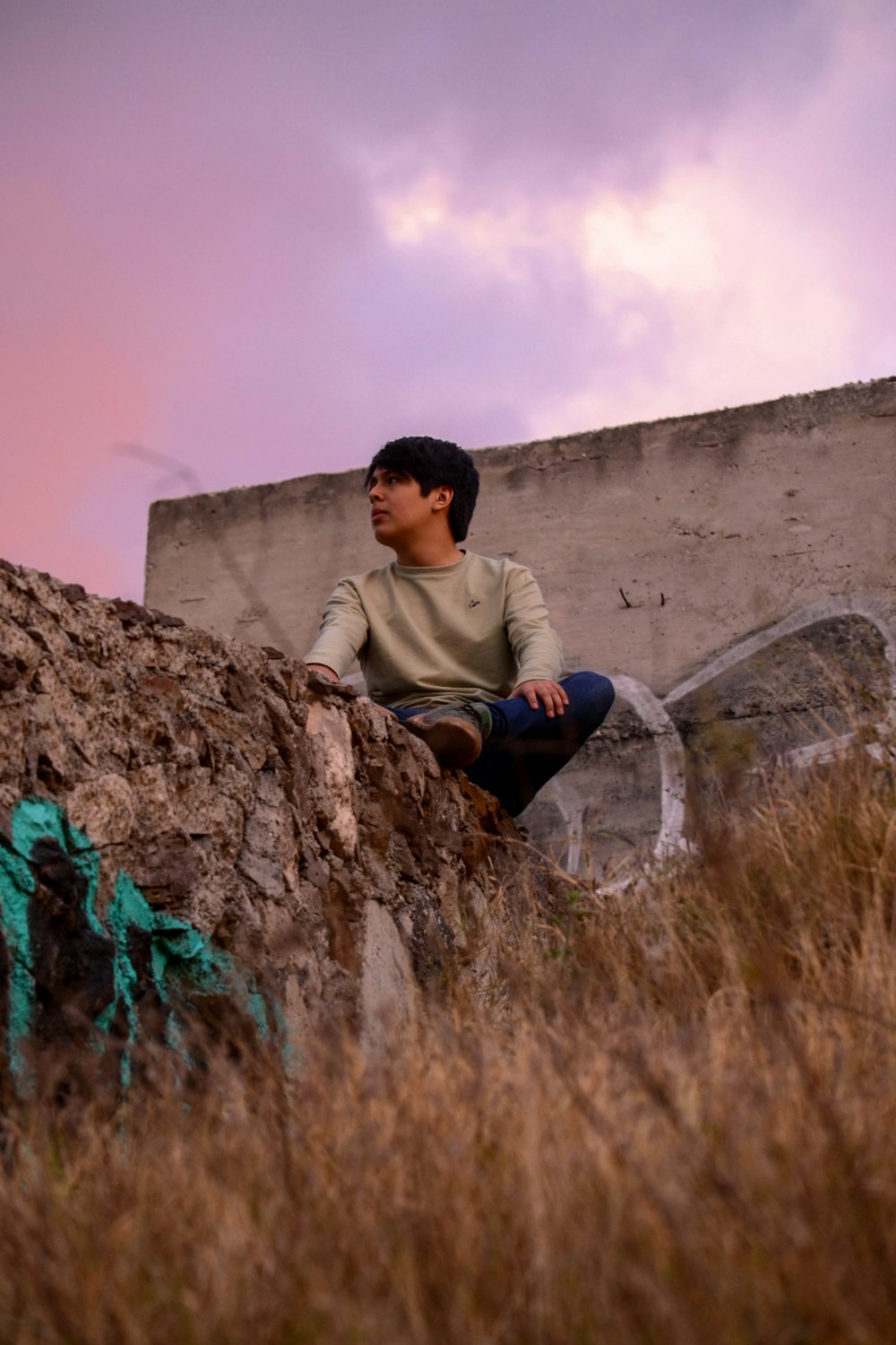 a man sitting on top of a large rock