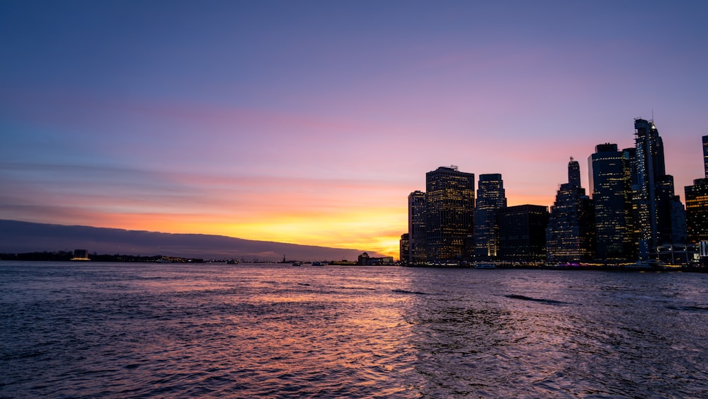 a view of a city at sunset from the water