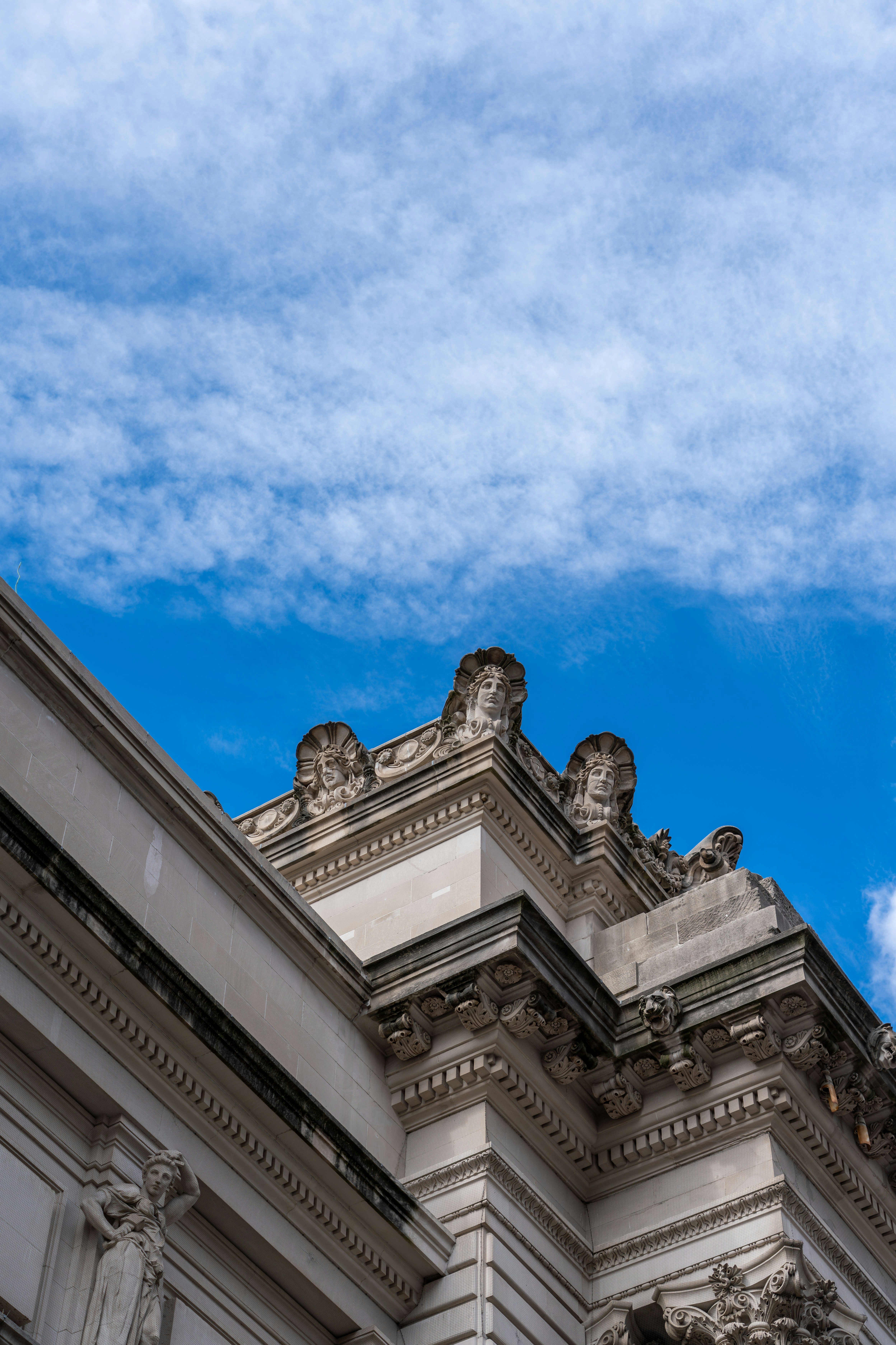 a clock on the side of a building under a blue sky