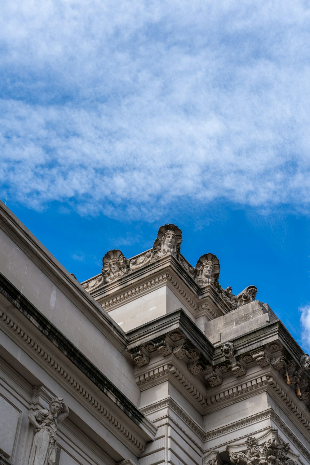 a clock on the side of a building under a blue sky