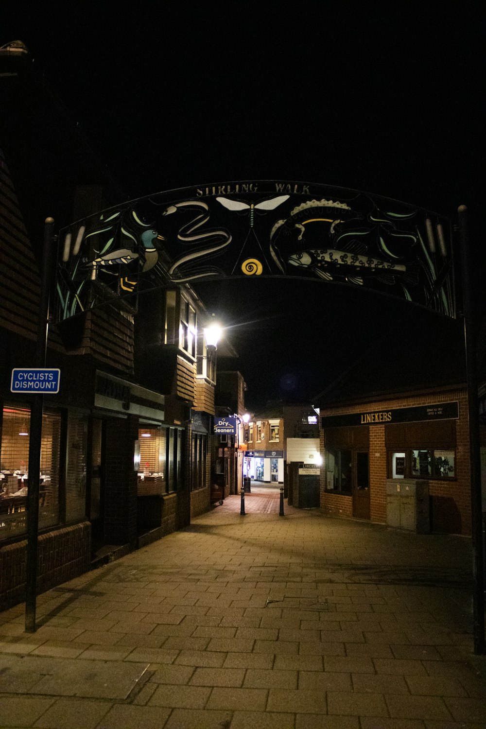 a city street at night with a lit up sign