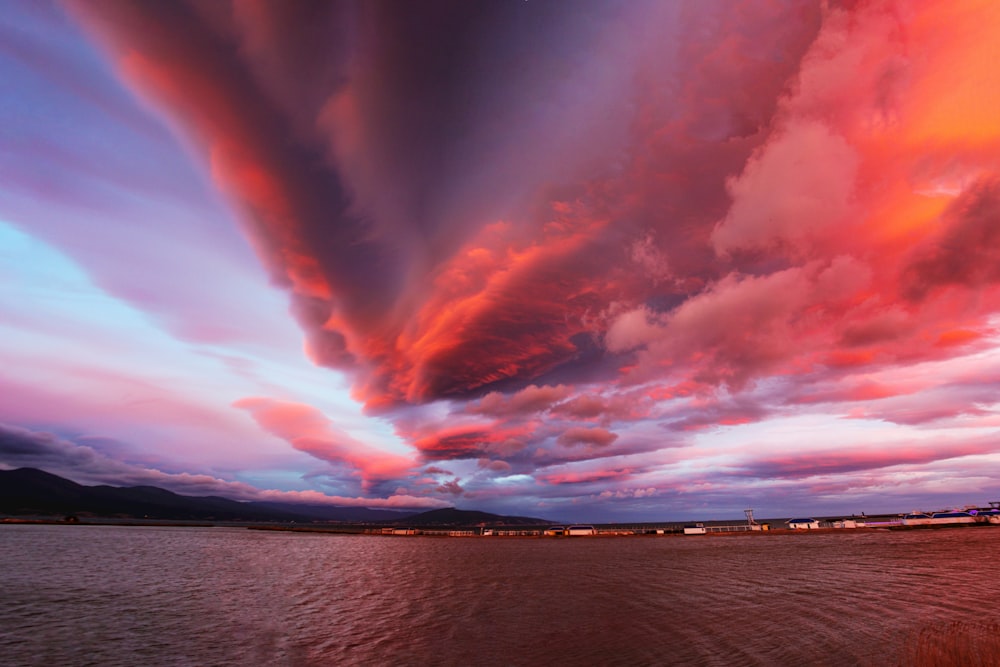 a red and blue sky over a body of water