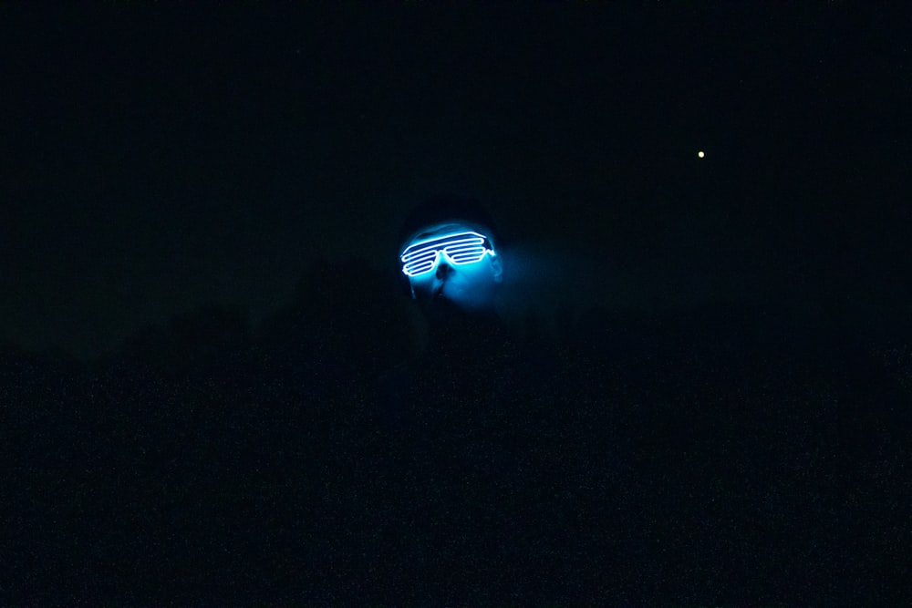 a person wearing glasses in the dark at night