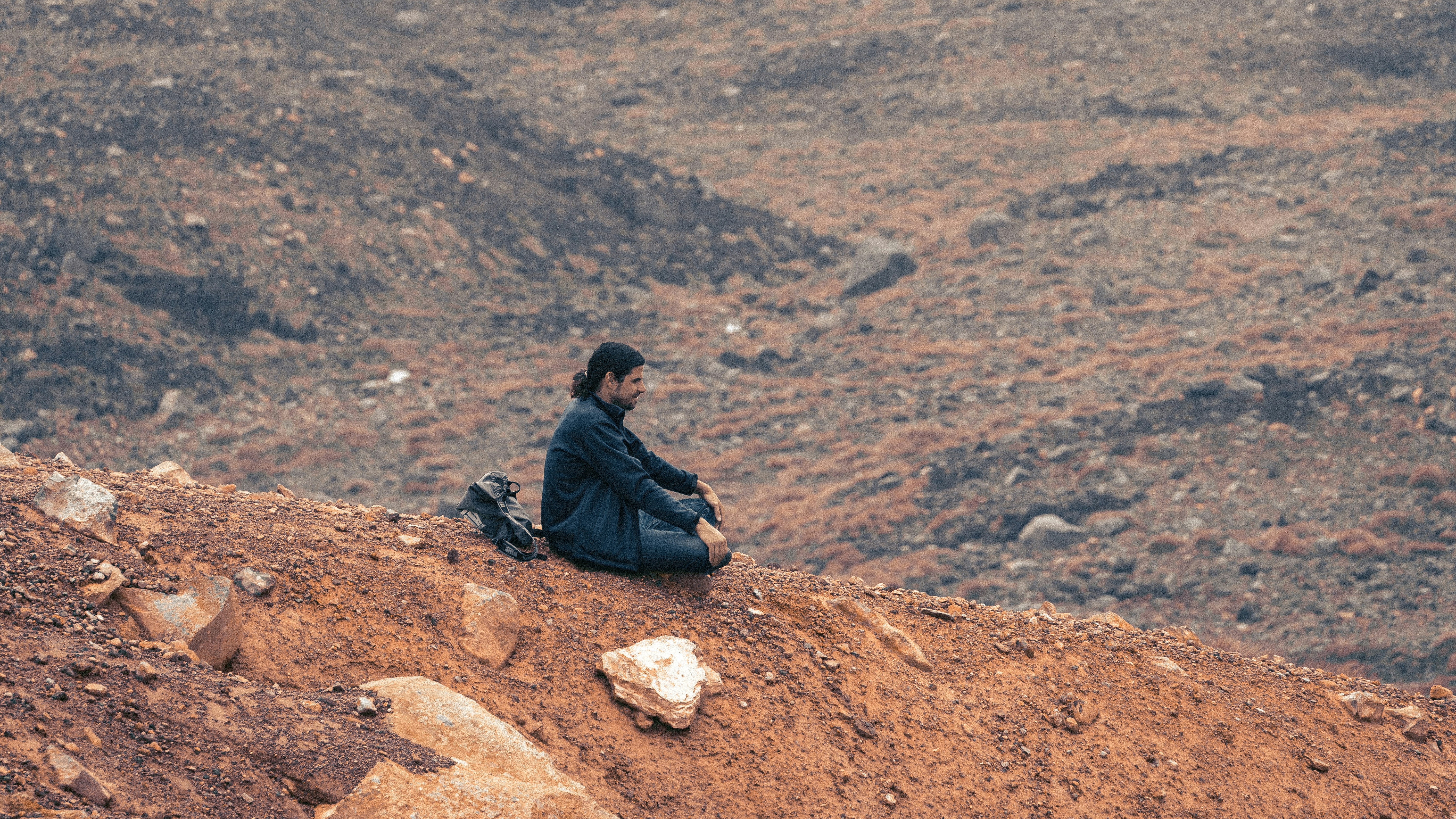 a man sitting on top of a dirt hill