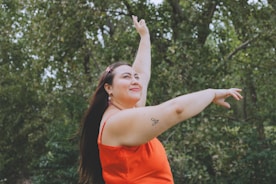 a woman in an orange dress throwing a frisbee