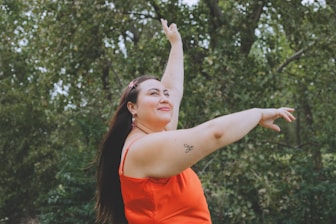 a woman in an orange dress throwing a frisbee