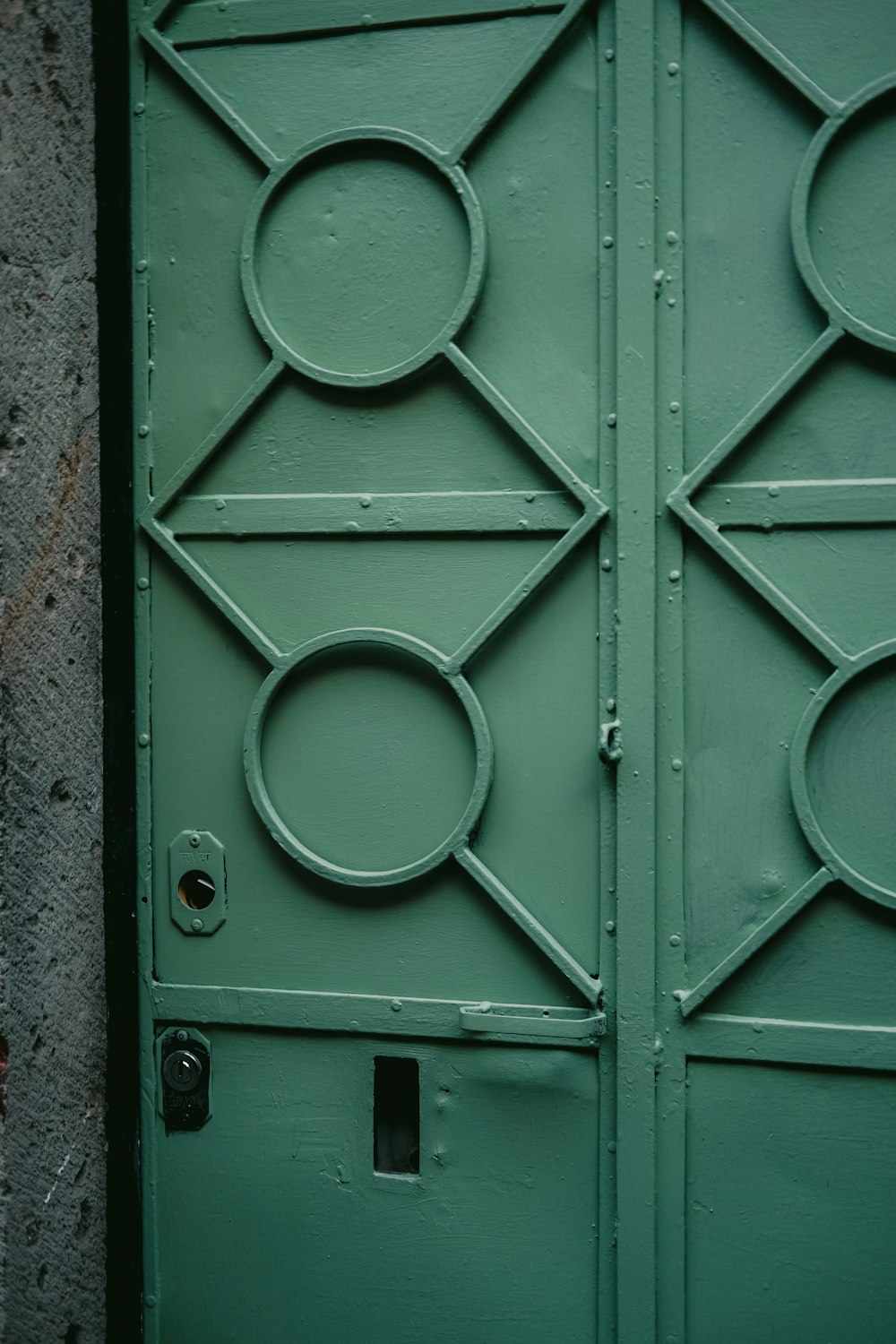 a close up of a green door with circles on it