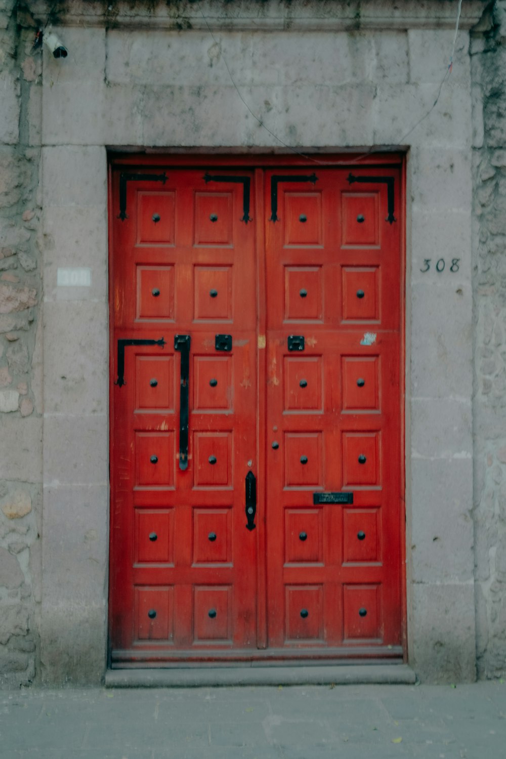 ein paar rote Türen, die an der Seite eines Gebäudes sitzen