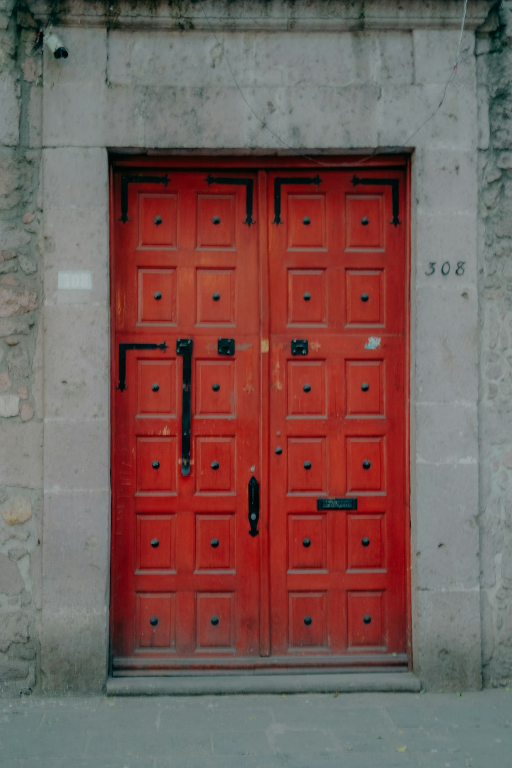 a couple of red doors sitting on the side of a building