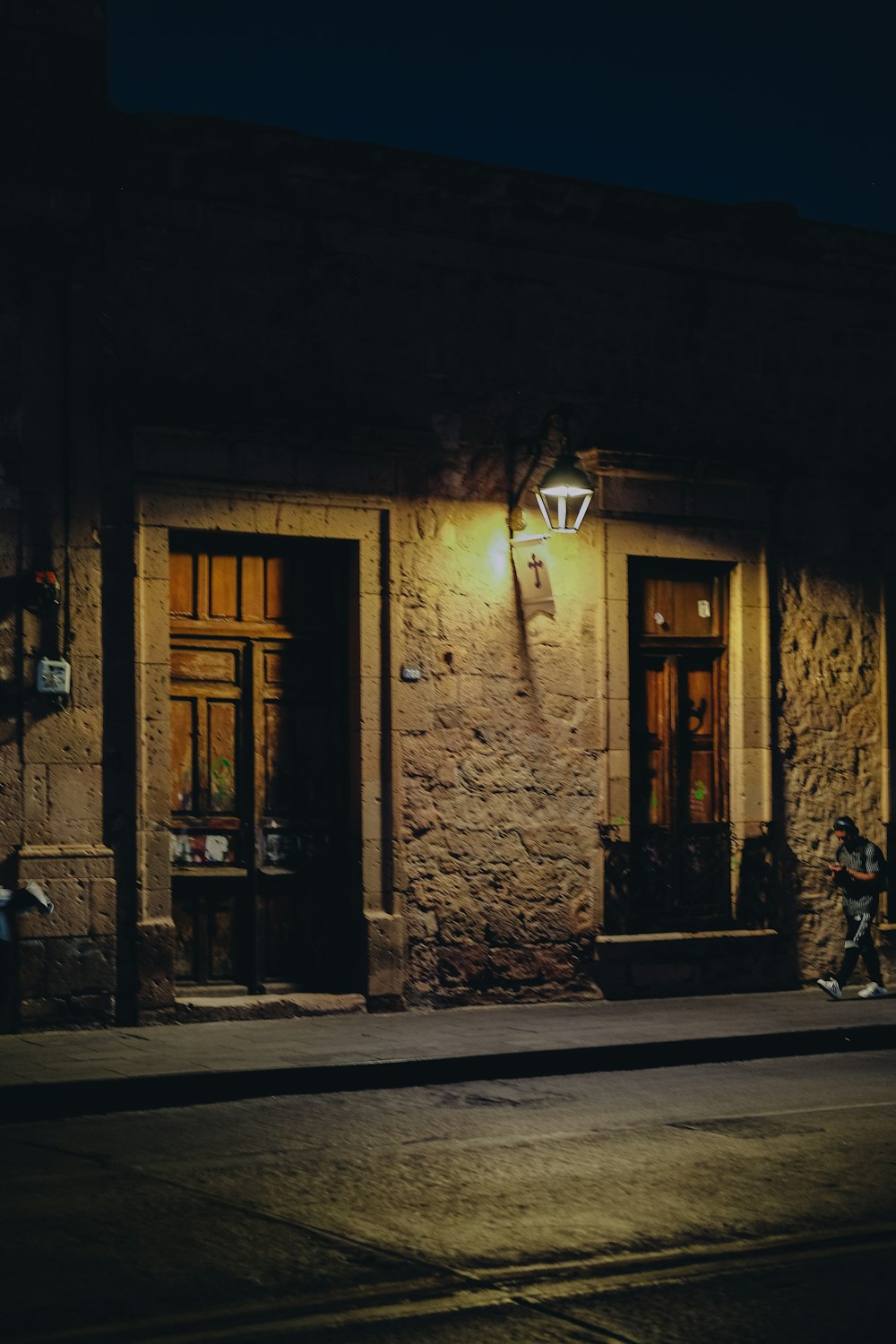 una calle oscura por la noche con un edificio iluminado