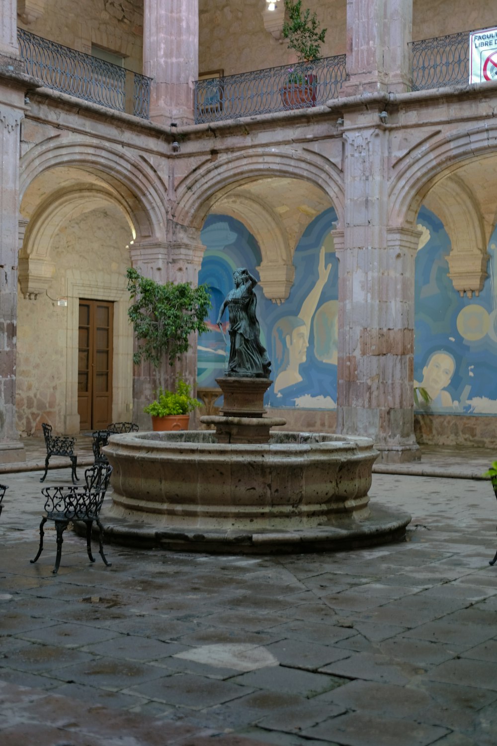 a courtyard with a fountain and benches in it