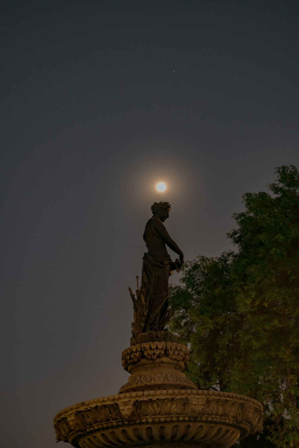 a statue of a man standing on top of a fountain