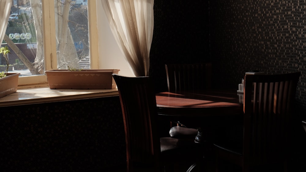 a table and chairs in a room with a window