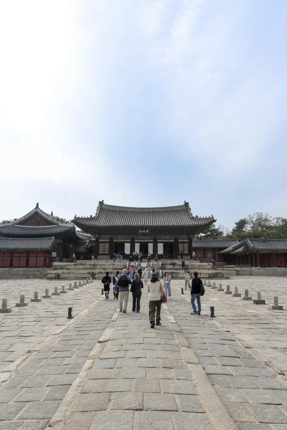 a group of people walking across a stone walkway