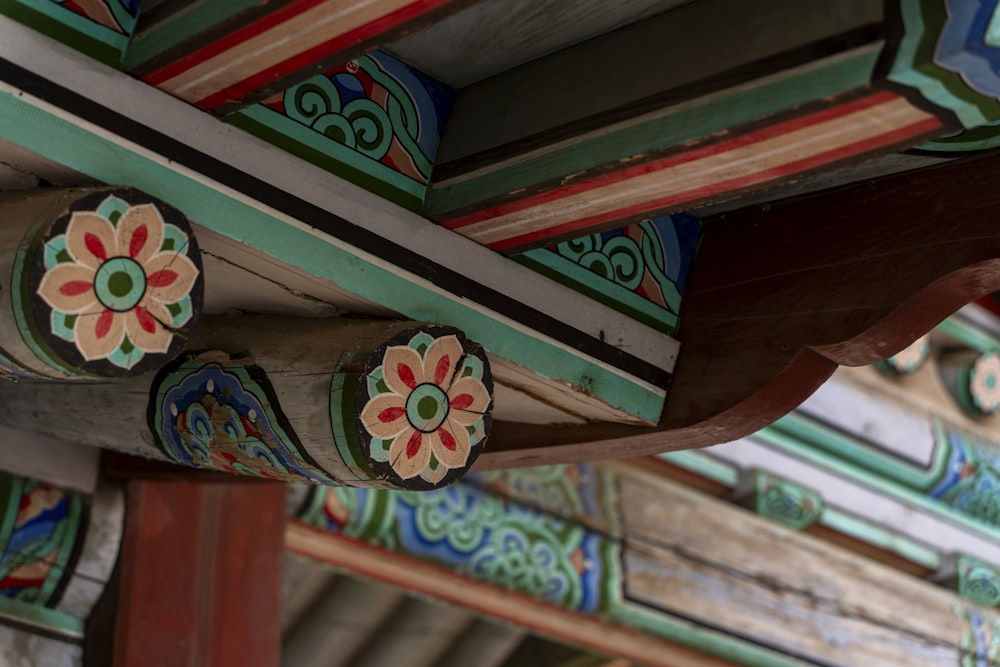 a close up of a wooden structure with flowers painted on it