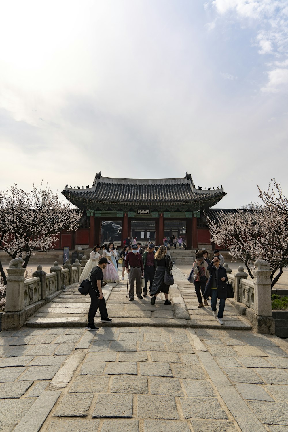 a group of people walking down a walkway next to a building