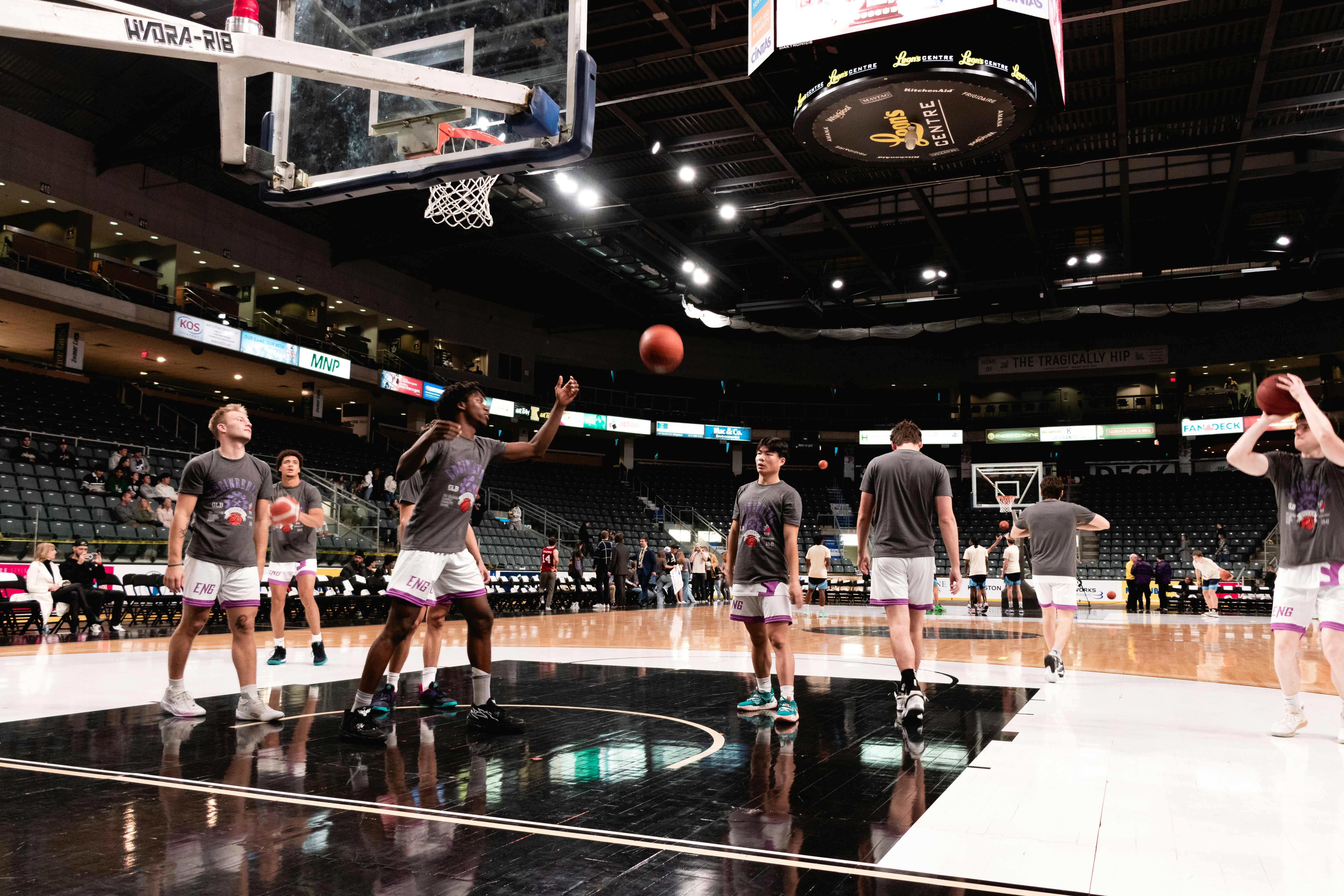 a group of men standing on top of a basketball court