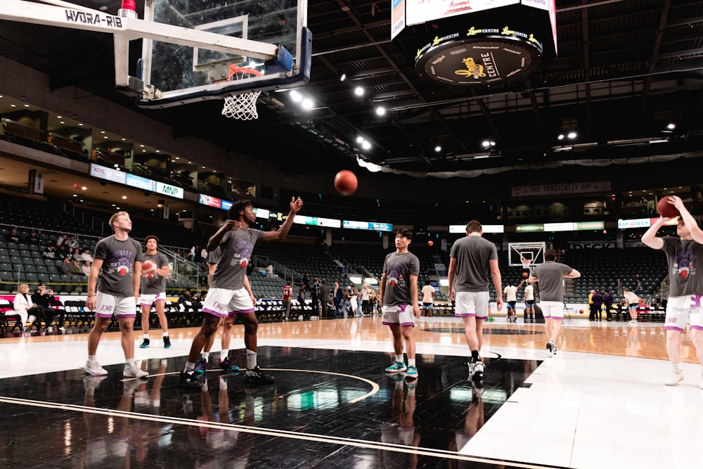 a group of men standing on top of a basketball court