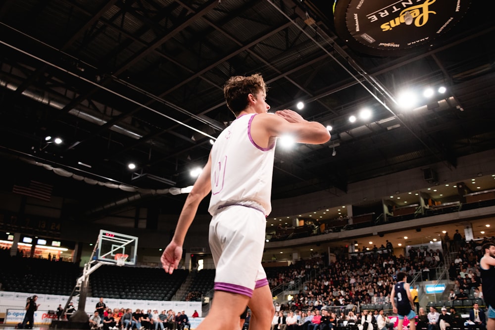 a man standing on top of a basketball court holding a basketball