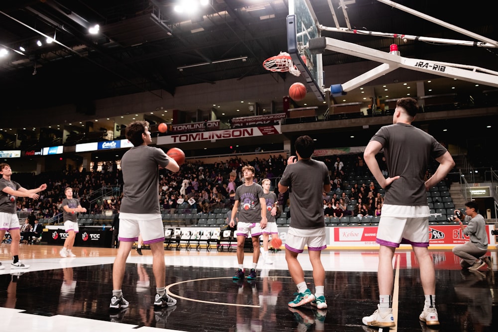 a group of men standing on top of a basketball court