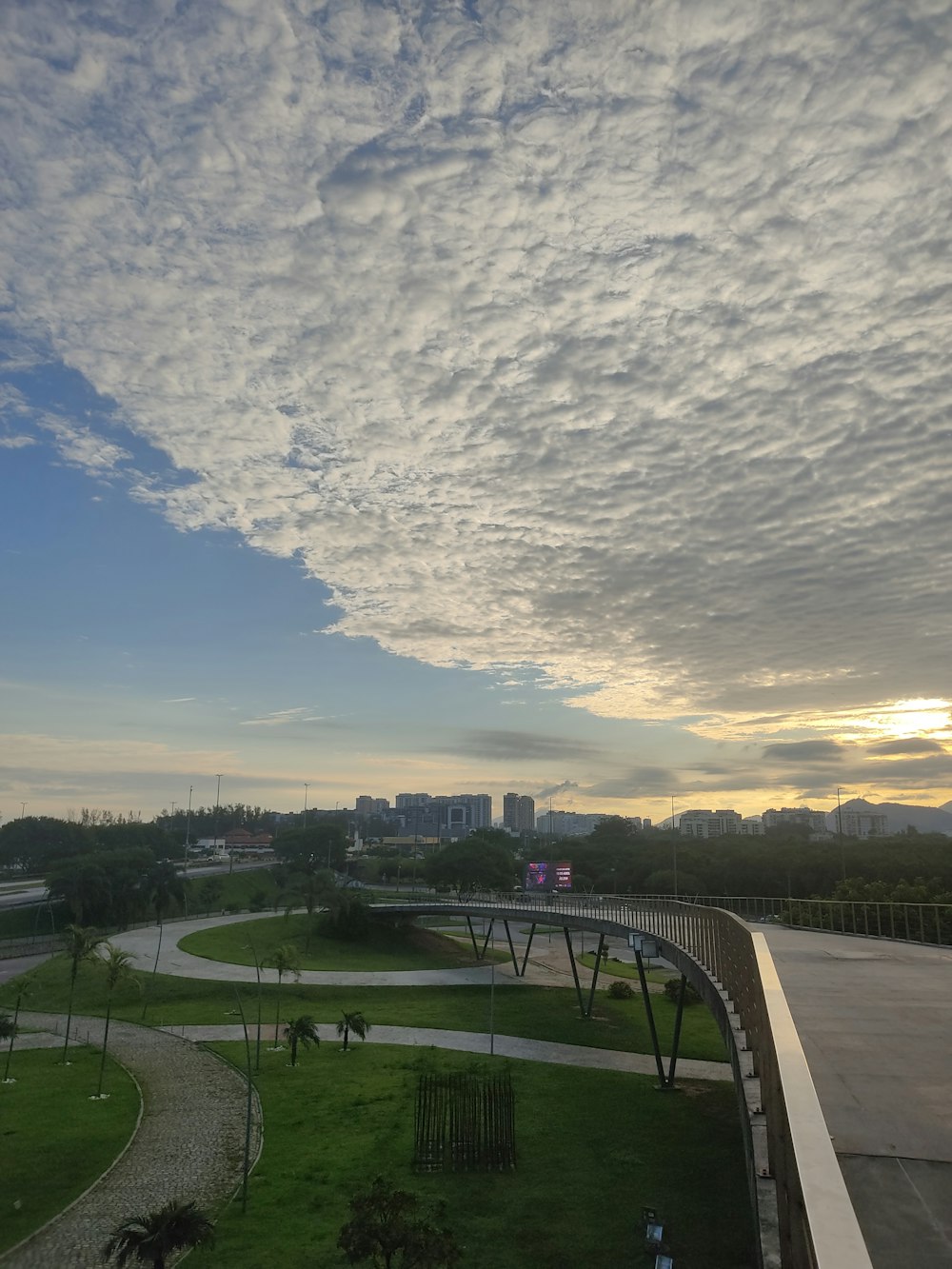 a view of a park with a bridge in the background