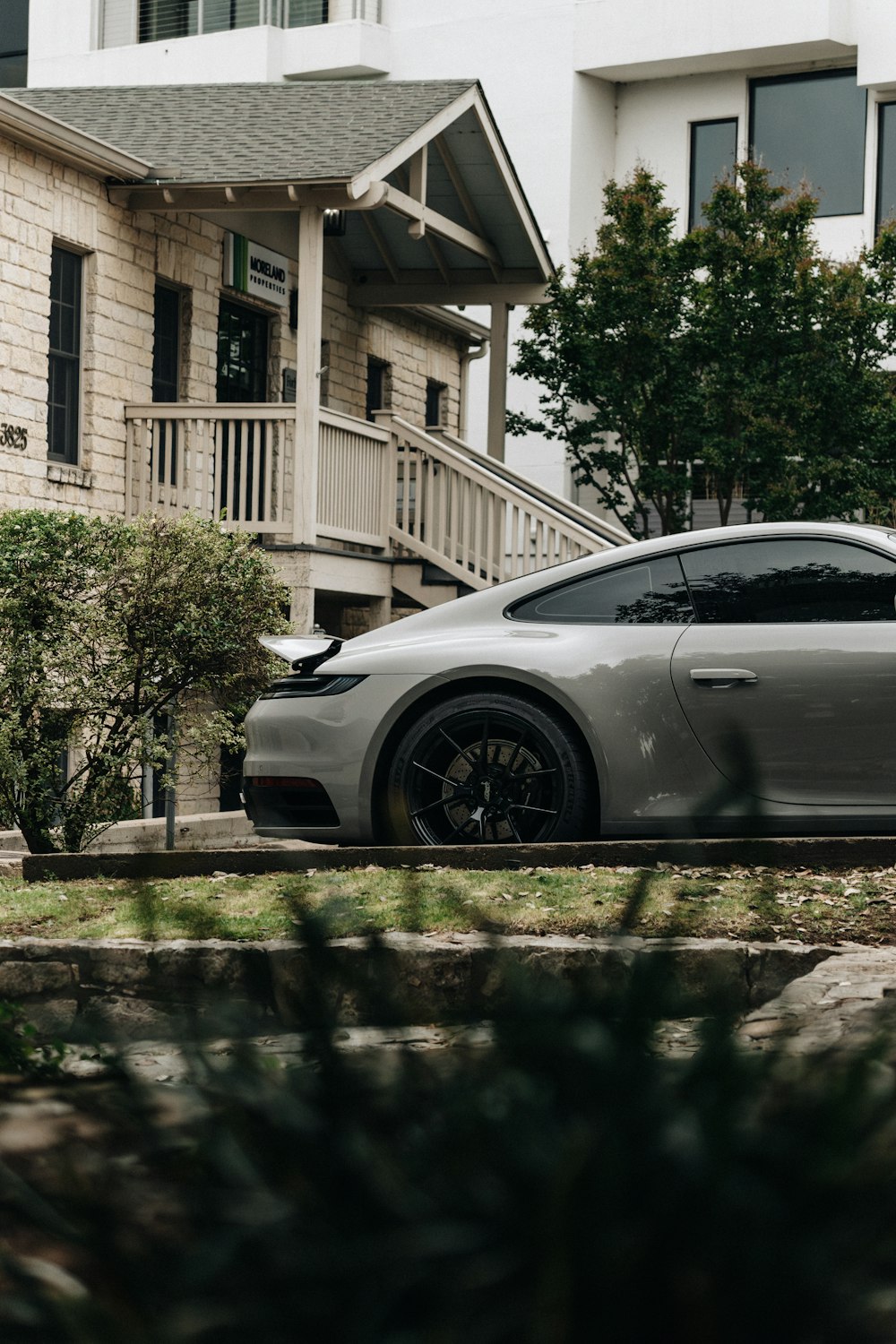 a grey sports car parked in front of a house