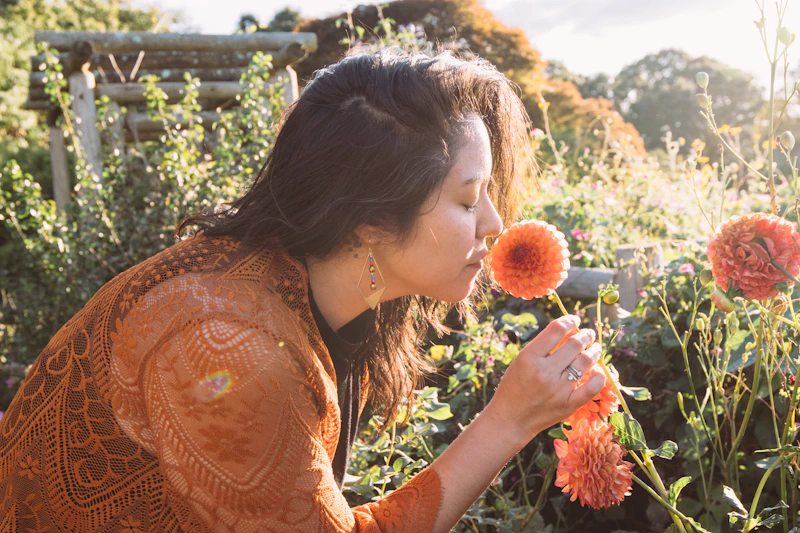 mujer disfrutando el aroma de una flor