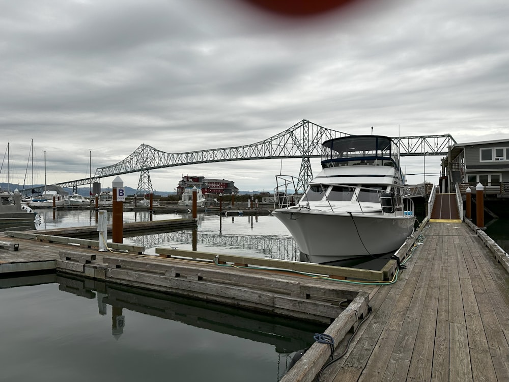 a boat docked at a dock with a bridge in the background