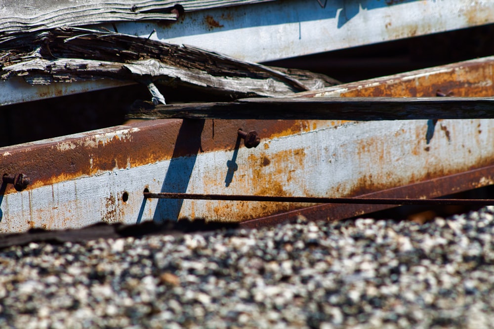 a rusted metal structure sitting on top of a pile of gravel