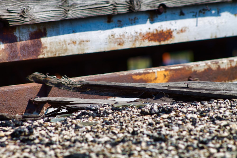 a broken piece of wood sitting on top of a pile of gravel