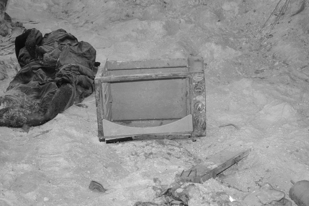 Un viejo televisor en el suelo junto a una pila de ropa