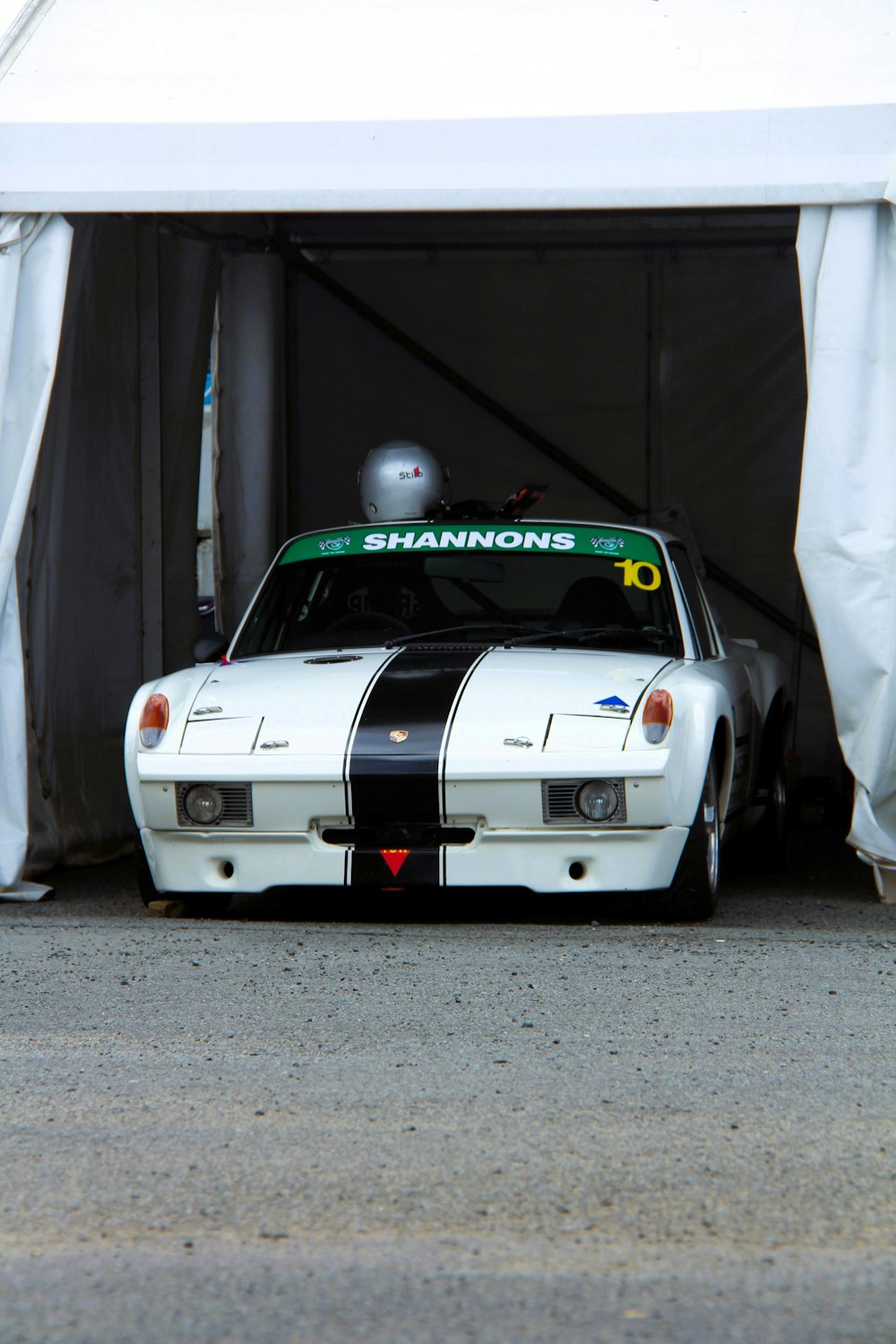 a white car with a black stripe parked in a garage