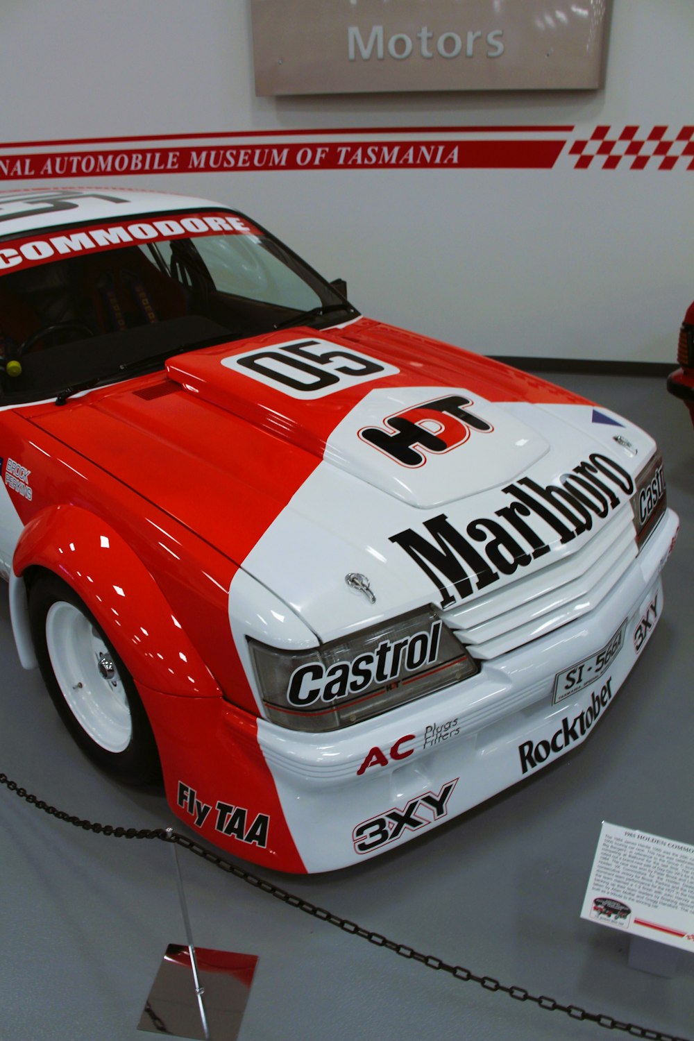 a red and white car is on display in a museum