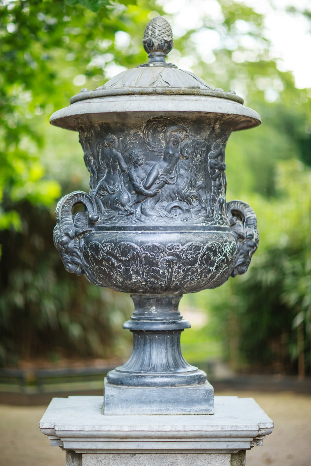 a large metal urn sitting on top of a cement slab