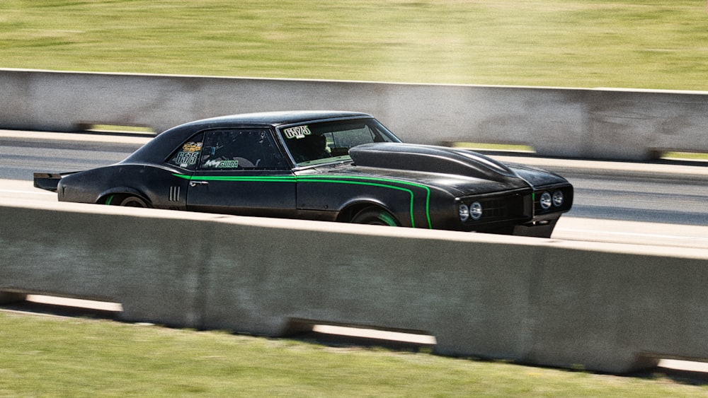 a black and green car driving down a highway