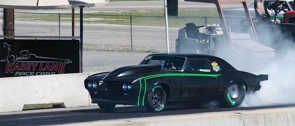 a black car with a green stripe on the side of it