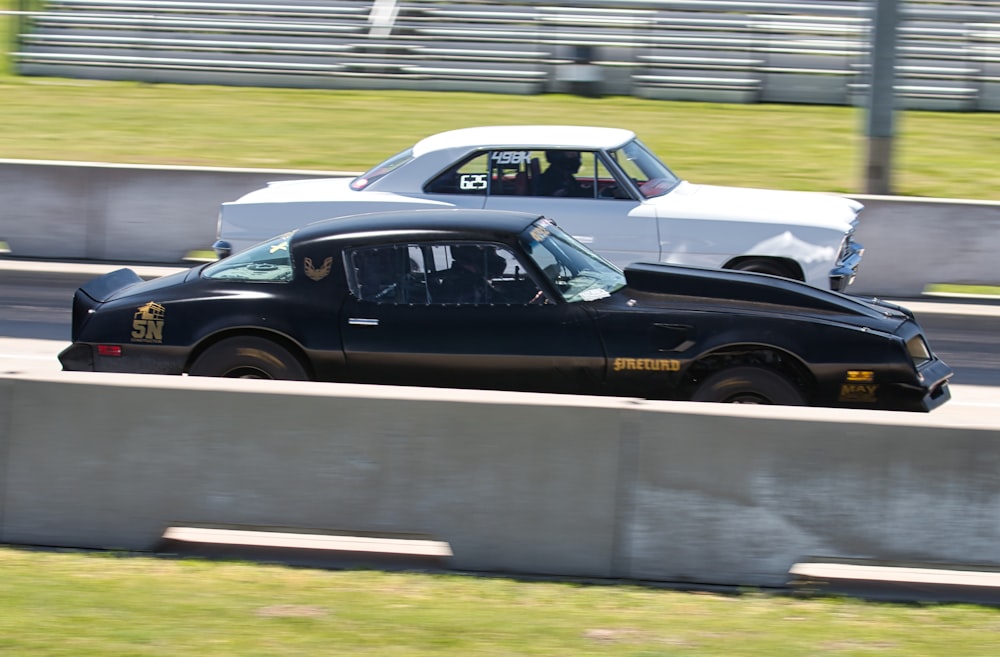 two cars driving on a race track next to each other