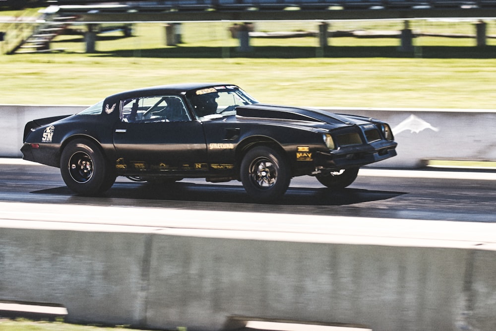 a black car driving down a race track