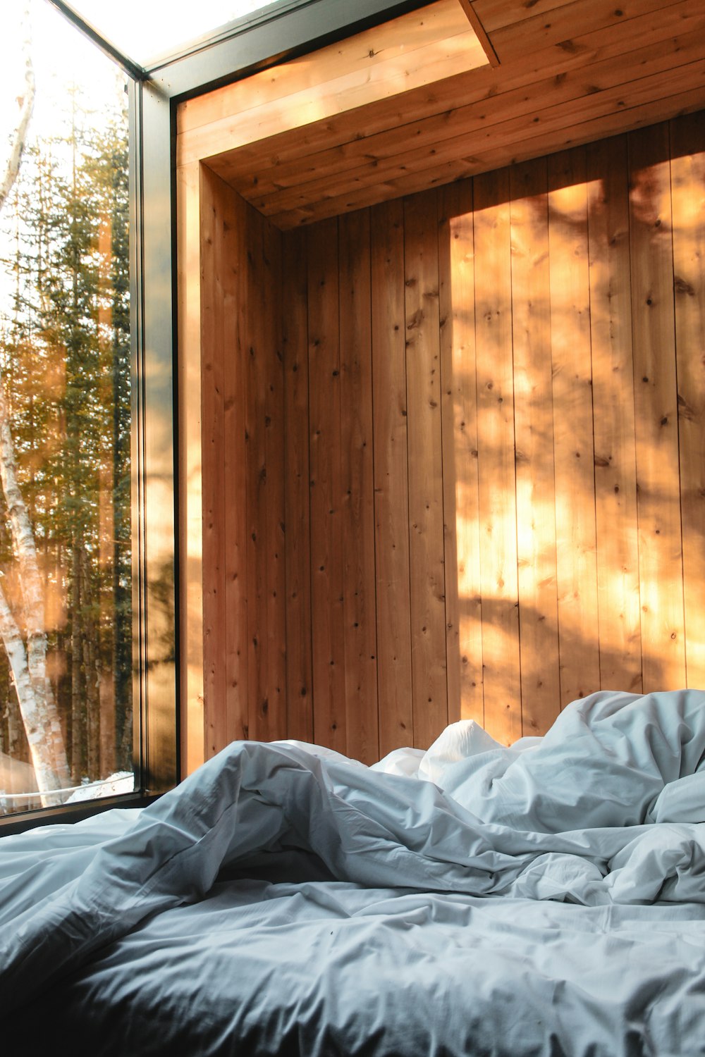 a bed in a room with a wooden wall