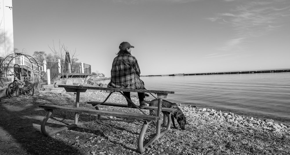 a man sitting on a bench near the water