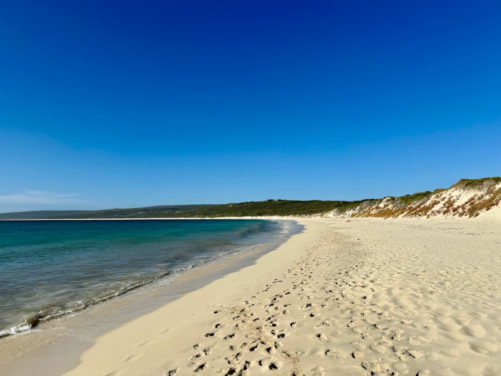 a sandy beach with footprints in the sand